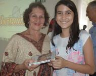Maria Carolina Paiva entrega o brinde Ã  Mary